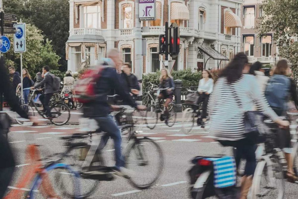 Persone che vanno in bicicletta in sicurezza in città, percorrendo piste ciclabili.
