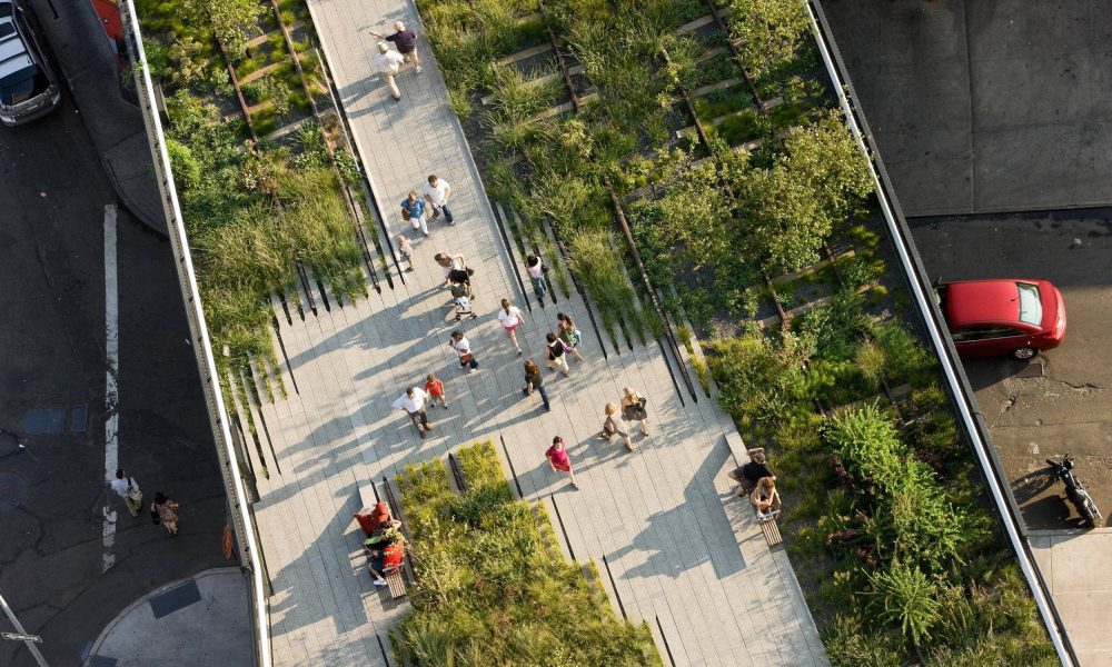 High Line, New York. Vista dall'alto della linea ferroviaria trasformata in parco urbano. Vasi con piante e fiori. Persone che camminano