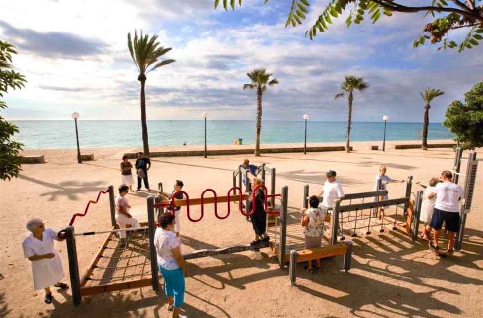 Anziani fanno attività fisica in un'area attrezzata in riva al mare